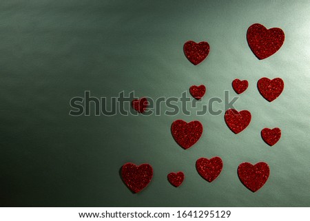 Valentine's Day, romance, still life, red hearts are laid out, blurred green background, shallow depth of field. Beautiful holiday picture.