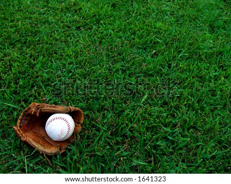 Softball glove and mitt on grass field. Royalty-Free Stock Photo #1641323