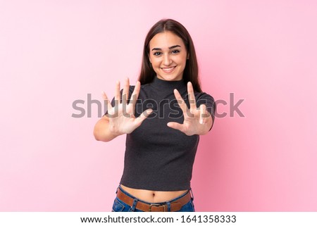 Young girl over isolated pink background counting eight with fingers