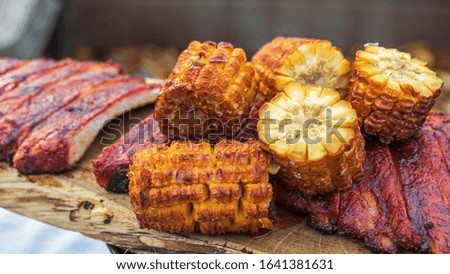 Street food on the grill. Skewered meat and corn, barbecue. Outside. Horizontal photo.