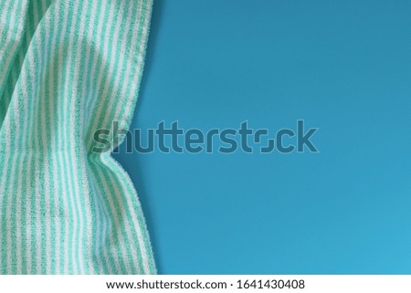 Soft terry cotton towel on a blue background. Bath towel. Personal hygiene items.

