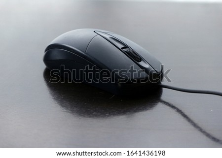 Photo of a computer mouse on a wooden table.