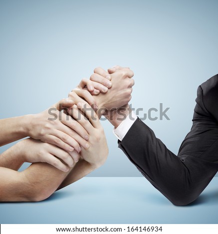 arm wrestling: businessman in opposition with many hands on blue background
