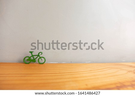 a stainless bicycle model on grey wall and wood table. healthy lifestyle. exercise