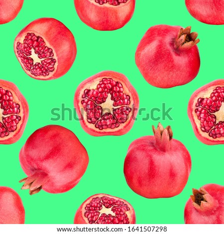 Seamless pattern of red pomegranates on green background isolated close up, whole and cut pomegranate with seeds repeating ornament, detox diet backdrop concept, antioxidant garnet fruits wallpaper