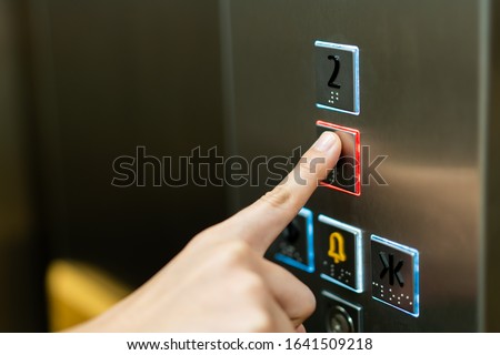 People pressing the button in the lift and select the first floor by using the forefinger. Elevator control panel in small building close up. Bell alphabet on the button in the passenger lift. Royalty-Free Stock Photo #1641509218
