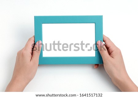 Hand holding blank photo frame for copy space on white background.