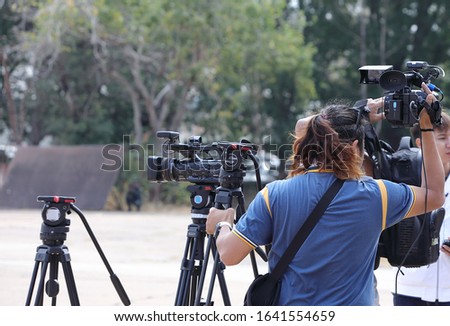 Cameraman.The person who set up the camera shoots video outdoors. Royalty-Free Stock Photo #1641554659