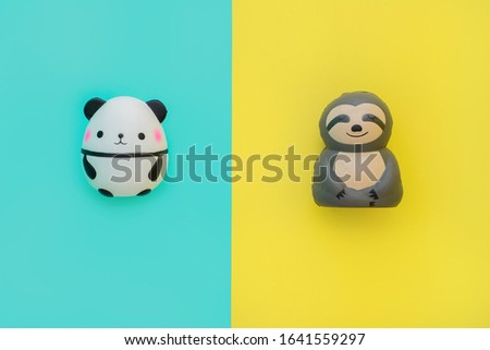 Flat lay antistress toys: squish panda, sloth with mouth, eyes, nose. Bright yellow blue background.Compressing, soft, squeezable items to relieve stress, problems, anxieties, worries.Summer concept.