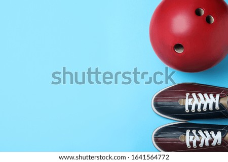 Bowling ball and shoes on light blue background, flat lay. Space for text