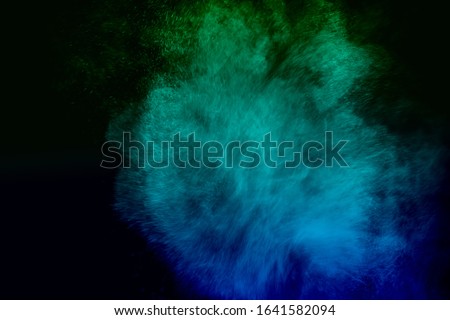or powder explosion cloud isolated on black background. Freeze motion of color dust particles splashing.