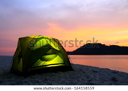 green tent on beach in sunset