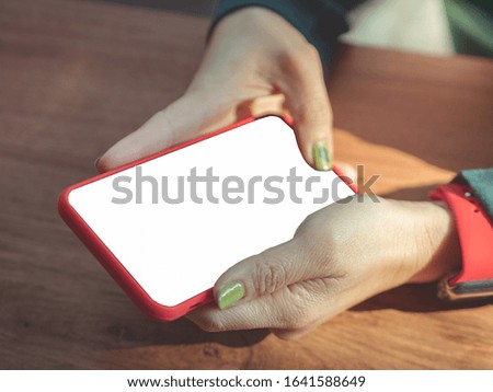 Woman hand holding red smartphone with blank screen isolated on white background