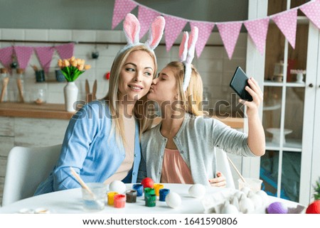 Happy mother and daughter  take a picture selfie wearing in bunny ears. Preparing for Easter - Image