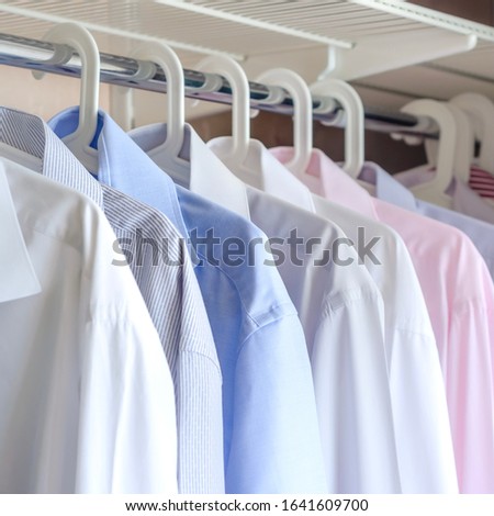 multi-colored ironed men's shirts hang on a hanger, selective focus