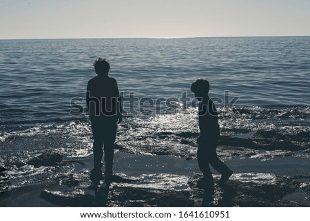 Children playing in rocky pools in the Mediterranean sea. Kid Silhouette photography at the beach. kids relaxing at the seaside during holiday.