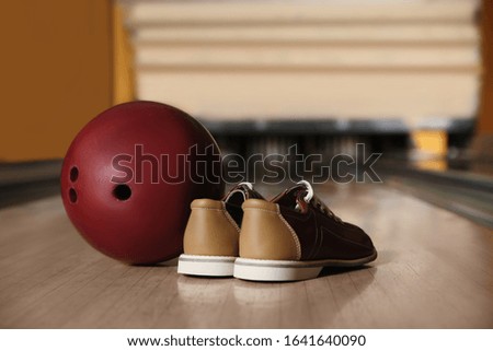 Shoes and ball on alley in bowling club