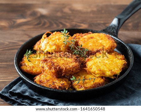 Potatoes pancakes latkes, flapjacks, hash brown or potato vada on brown wooden table. Copy space for text. Royalty-Free Stock Photo #1641650548