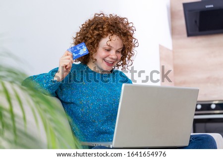 Cute red hair woman shopping online with credit card. woman holding credit card and using laptop. Online shopping concept