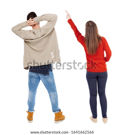 Back view of couple couple in sweater pointing. beautiful friendly girl and guy together. Rear view people collection. backside view of person. Isolated over white background.