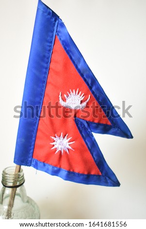 It is Nepal's national flag. It has unique traingular shape with moon and sun in red background with blue border