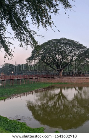 Sukhothai Historical Park, a UNESCO World Heritage Site in Thailand, beautiful bridge under lake to old chedi ruins, mobile photo