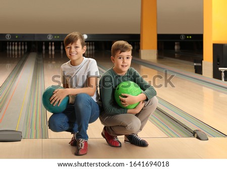 Happy boys with balls in bowling club