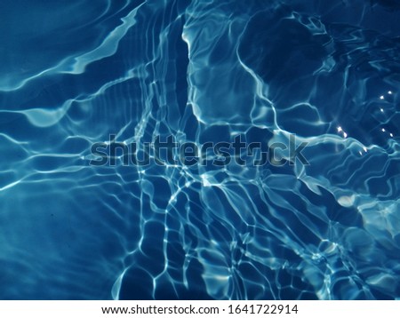 The pattern​ of metal​ texture​ of​ surface​ blue​ water​ in​ the​ deep​ sea​ for​ background. Blue​ water​ texture​ for​ background​