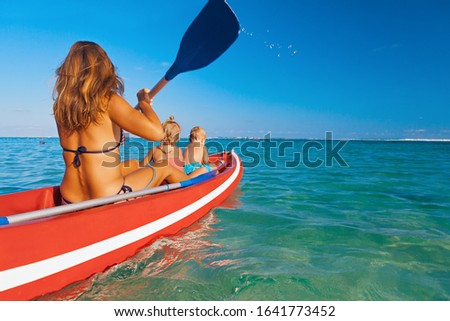 Happy family - young mother, children have fun on boat walk. Woman and child paddling on kayak. Travel lifestyle, parents with kids recreational activity, watersports on summer sea beach vacation.