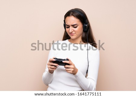 Young woman over isolated background playing at videogames