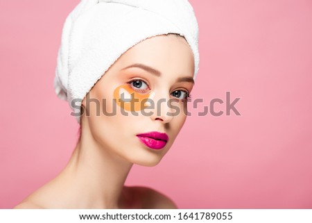 beautiful woman in eye patch looking at camera isolated on pink