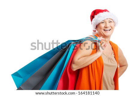 An old woman holding presents/bags in santa hat. Isolated on white. 