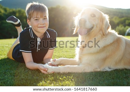 A child with a dog in nature.