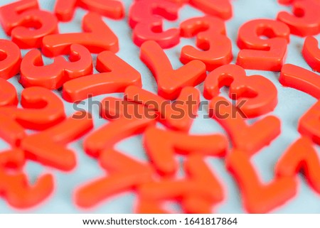 Selective focus of red plastic numbers on blue background