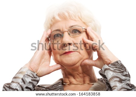 An old woman touching her face/temples. Isolated on white. 
