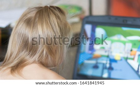 Back of head child looking at screen laptop watching cartoons