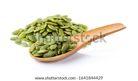 Pumpkin seeds in wood spoon isolated on a white background. full depth of field