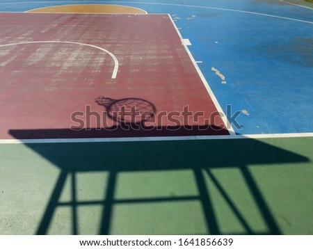 colorful basketball lines on an outdoor court with shadow