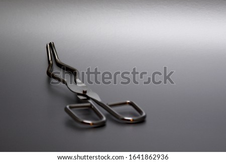 Crucible Tongs stock images. Laboratory tweezers images. Laboratory accessories images. Laboratory equipment on a silver background with copy space for text