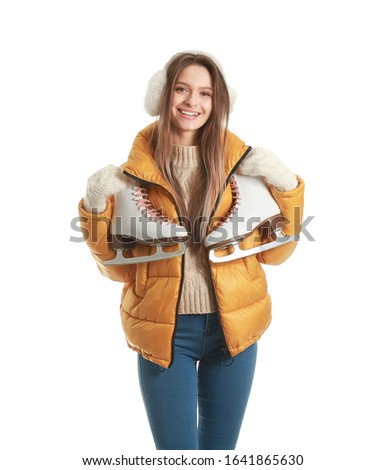 Beautiful young woman with ice skates on white background