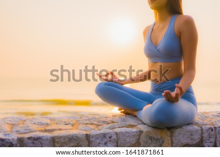 Portrait young asian woman do meditation around sea beach ocean at sunrise for health
