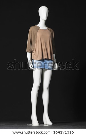 full-length mannequin in shirt and jeans shorts-black background 