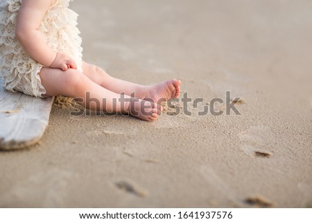 Child feet on a beach sand.
