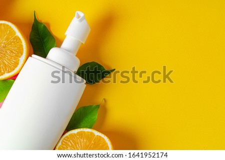 Bottle of skincare cosmetics with sliced lemons
