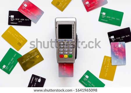 Bank terminal for payments among plastic cards on white background top-down