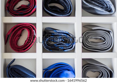 Many ties arranged in a drawer. Symbol of organization, style, elegance. Business man. Male fashion object.