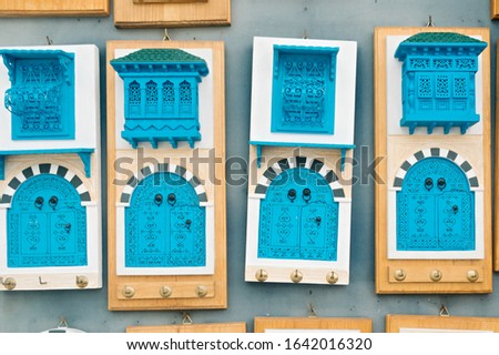 Closeup souvenirs key holders with a mirror inside in the form of traditional famous doors and balconies of the blue city of Sidi Bou Said, Tunisia, North Africa