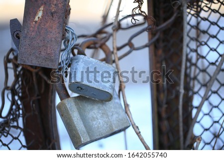 Close-up on locks in different hanging on Iron rusty fence. Old rusty lock on the vintage rural metal door. steam punk. Scenic view of the structural architectural landscape. old gate. selective focus