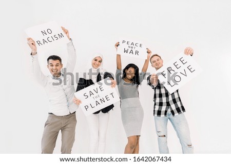 Young four multiethnical activists, volunteers, ecologists with banners shouting about racism, saving earth, no war, equal rights, standing isolated on white background