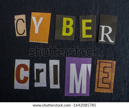 the inscription cyber crime glued on a dark surface paper letters cut from different newspapers by anonymous